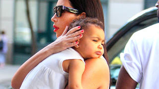 Kim Kardashian and husband Kanye West took their daughter North West to the Children's Museum in New York City. On the way in, baby North slept on her mother's shoulder.