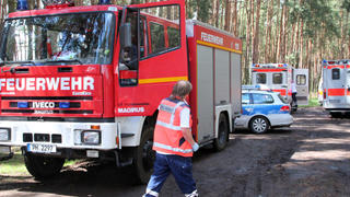 Fahrzeuge von Feuerwehr und Polizei stehen am 12.07.2014 in Klaistow (Brandenburg) nach einem Blitzeinschlag unter Bäumen. Fünf Menschen sind nach Polizeiangaben hier am Rande des Mud Day (Matschtag) verletzt worden. Foto: Oliver Schwandt/dpa +++(c) dpa - Bildfunk+++