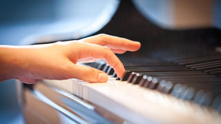 Die Hand an der Tastatur einer Japanischen Pianistin, die klassische Musik spielt, aufgenommen im Mai 2013 in Nara.