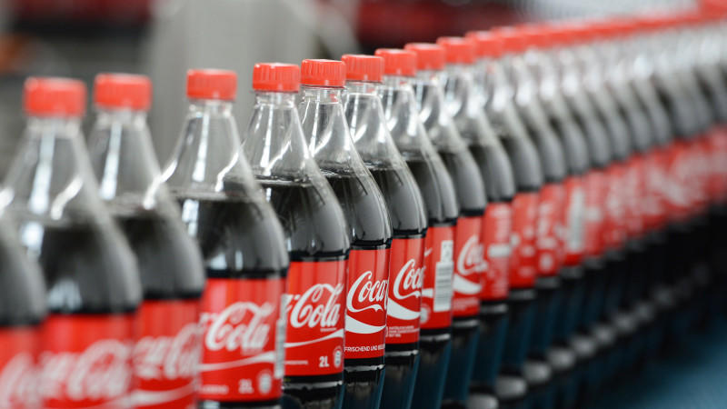 Zwei-Liter-Getränkeflaschen mit Coca Cola stehen am 21.08.2013 auf einem Transportband. Foto: Jens Kalaene/dpa