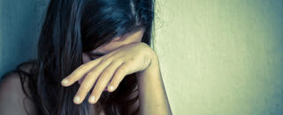Sad and lonely girl crying with a hand covering her face (with space for text)