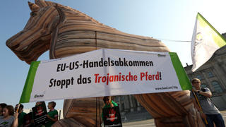 Demonstranten nehmen am 16.09.2014 vor dem Reichstagsgebäude in Berlin an einer Protestaktion des BUND "EU-US-Freihandelsabkommen TTIP - Trojanisches Pferd stoppen!" teil. Foto: Wolfgang Kumm/dpa +++(c) dpa - Bildfunk+++
