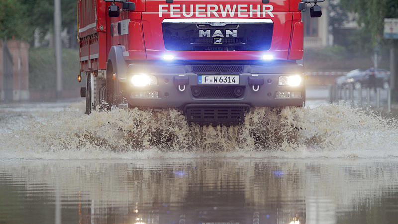 Die Feuerwehr fährt durch eine überflutete Straße in Wiesbaden