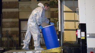 epa04462495 A worker transports a plastic barrel, to be brought the the Center for Disease Control (CDC) from the apartment building where Ebola patient Craig Spencer lived in Harlem, New York, USA, 24 October 2014. Spencer was taken to an isolation ward at Bellevue Hospital Center 23 October morning after he began suffering a fever and exhibiting gastrointestinal symptoms characteristic of Ebola. Bassett said that the patient was in stable condition and has been able to talk to his family on the phone. On 24 October medical detectives were in the process of visiting and clearing every place, including a bowling alley, a restaurant and a coffee stand, that the patient had visited before developing a fever the day before. EPA/JOHN TAGGART +++(c) dpa - Bildfunk+++