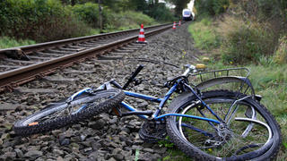 Neben den Gleisen liegt am 01.11.2014 das völlig zerstörte Fahrrad eines 12-jährigen Jungen aus Cloppenburg, der kurz zuvor bei einem Unfall mit einem Zug ums Leben gekommen ist. Das Kind stand laut Polizei mit seinem Fahrrad an der geschlossenen Schranke, als es vermutlich durch den Sog an den Zug herangezogen und mehrere Hundert Meter mitgeschleift wurde. Die Zugstrecke wurde für mehrere Stunden gesperrt. Foto: Nord-West-Media TV/dpa (zu dpa '12-Jähriger von Zug erfasst und getötet' am 01.11.2014) +++(c) dpa - Bildfunk+++