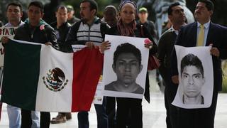 Demonstrators hold Mexican flag and portraits of missing students as they take part in a protest in support of the 43 missing students of the Ayotzinapa teachers' training college Raul Isidro Burgos, outside the Mexican Embassy in Bogota November 7, 2014. The students went missing in the town of Iguala in the south-western state of Guerrero on September 26 after clashing with police and masked men, with dozens of police being arrested in connection with a case that has sent shockwaves across Mexico. REUTERS/John Vizcaino (COLOMBIA - Tags: POLITICS CRIME LAW CIVIL UNREST EDUCATION)
