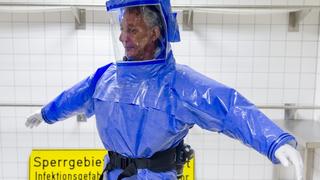 Ward physician Thomas Klotzkowski wears a protective suit at the quarantine station for patients with infectious diseases at the Charite hospital in Berlin August 11, 2014. The isolation ward at the Charite is one of several centres in Germany equipped to treat patients suffering from ebola and other highly infectious diseases, the clinic's doctor for tropical medicine Florian Steiner said. Ebola is one of the deadliest diseases known to humanity. It has no proven cure and there is no vaccine to prevent infection. The most effective treatment involves alleviating symptoms that include fever, vomiting and diarrhoea. The rigorous use of quarantine is needed to prevent its spread, as well as high standards of hygiene for anyone who might come into contact with the disease.  The sign reads: "Do not Enter. Infectious Diseases. No Trespassing!" REUTERS/Thomas Peter (GERMANY - Tags: HEALTH)
