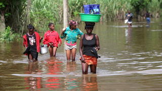 ARCHIV - Opfer einer Flut gehen am 11.11.2012 mit ihren Habseligkeiten über eine überflutete Straße auf Haiti. Die Weltbank warnt eindringlich vor den drastischen Folgen der Erderwärmung. Foto: Orlando Barria/dpa    (zu dpa « Weltbank warnt vor Erderwärmung von vier Grad» vom 18.11.2012)  +++(c) dpa - Bildfunk+++