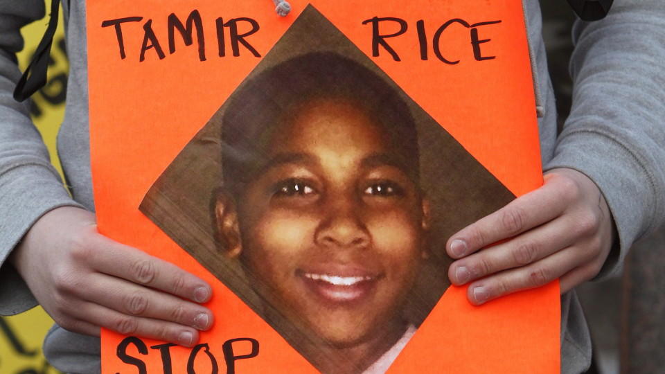 epa04502535 A protester holds a sign with a picture of Tamir Rice. during a rally at Public Square in Cleveland, Ohio, USA, 24 November 2014. Following the 22 November fatal shooting of 12 year old Tamir Rice by a Cleveland Police officer. According 