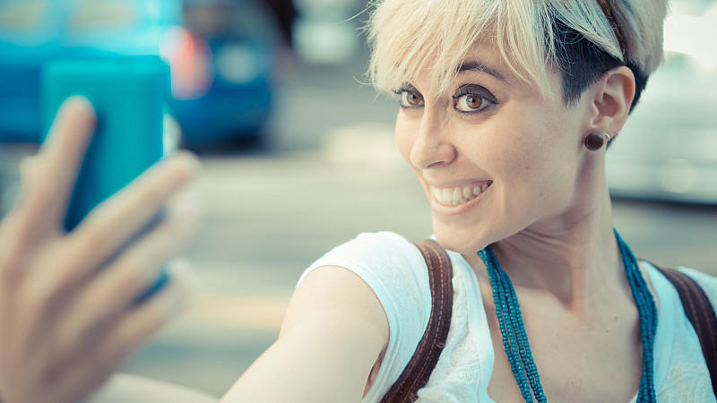 beautiful young blonde short hair hipster woman selfie in the city