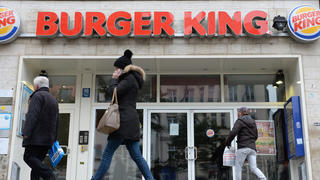 ARCHIV - Passanten gehen am 10.12.2014 an einer Filiale der Fast-Food-Kette Burger King in München (Bayern) vorbei. Foto: Andreas Gebert/dpa (Zu dpa "Burger King bringt Wiedereröffnung geschlossener Filialen auf den Weg" vom 12.12.2014) +++(c) dpa - Bildfunk+++