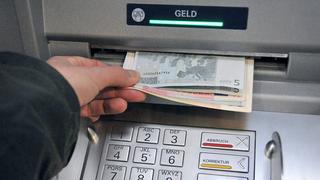 ARCHIV - Eine Hand entnimmt dem Geldschlitz eines Bankautomaten die gewünschten Banknoten (Archivfoto vom 07.11.2008). Geldautomaten in Deutschland werden immer häufiger manipuliert. Wie das Bundeskriminalamt (BKA) am Mittwoch (21.01.2009) in Wiesbaden berichtete, stieg die Zahl der Fälle im vergangenen Jahr stark an. Bundesweit hätten sich an 809 verschiedenen Geldautomaten Kriminelle zu schaffen gemacht, das entspricht einer Steigerung im Vergleich zum Vorjahr um 77 Prozent. Die Betrügereien verursachten einen Schaden von schätzungsweise mehr als 40 Millionen Euro. Foto: Uwe Zucchi (zu dpa 0460 vom 21.01.2009) +++(c) dpa - Bildfunk+++