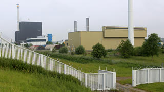 ARCHIV - Das atomare Zwischenlager (vorne) am Kernkraftwerk (l hinten) in Brunsbüttel (Schleswig-Holstein), aufgenommen am 20.06.2013.In Kiel wird das zuständige Ministerium am Nachmittag über die Auswirkungen eines Beschlusses des Bundesverwaltungsgerichts zur Genehmigung der Lagerung von hochradioaktiven Brennelementen im Zwischenlager Brunsbüttel informieren. Foto: Christian Charisius/dpa +++(c) dpa - Bildfunk+++