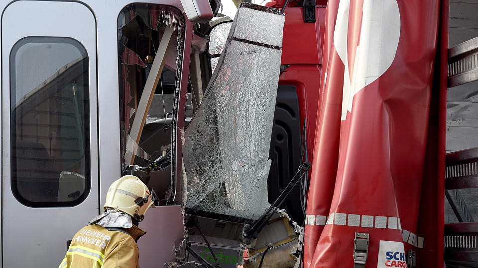 Ein Feuerwehrmann sichert das Fahrerhaus einer Straßenbahn, nachdem sie mit einem Lkw zusammengestoßen ist.