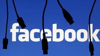 Electronic cables are silhouetted next to the logo of Facebook in this September 23, 2014 file illustration photo in Sarajevo.  Facebook appeared to be down early Janaury 27, 2015, with the social media site saying it is working on fixing the issue. "Sorry, something went wrong. We're working on it and we'll get it fixed as soon as we can," Facebook said on its website.     REUTERS/Dado Ruvic/Files (BOSNIA AND HERZEGOVINA  - Tags: BUSINESS TELECOMS)