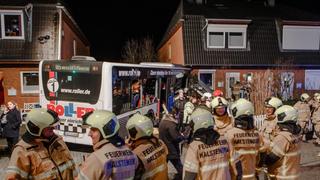 Feuerwehrleute stehen am 31.01.2015 in Hamburg-Eidelstedt vor einem verunglückten Linienbus, der in ein Wohnhaus gefahren ist. Bei dem Unglück wurden nach Angaben eines Feuerwehrsprechers acht der elf Businsassen verletzt, zwei von ihnen schwer. Foto: Markus Scholz/dpa +++(c) dpa - Bildfunk+++