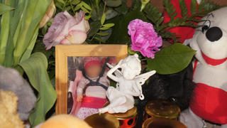 Kerzen, Blumen und ein Foto des schwer misshandelten Kleinkindes aus Bismark liegen am 06.02.2015 in Bismark (Sachsen-Anhalt) vor dem Wohnhaus. Das 18 Monate alte Mädchen ist tot. Foto: Jan Helmecke/dpa (zu lah «Misshandeltes Kleinkind tot» vom 06.02.2015) +++(c) dpa - Bildfunk+++