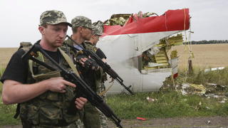 epa04321057 Armed pro-Russian militants pass next to the wreckage of a Boeing 777, of Malaysia Arilines flight MH17 debris, which crashed during flight over the eastern Ukraine region near Donetsk, Ukraine, 18 July 2014. A Malaysia Airlines plane with 295 people on board crashed on 17 July in eastern Ukraine, and both the government and separatist rebels fighting in the area denied shooting it down. All passengers on board Flight MH17 from Amsterdam to Kuala Lumpur are feared dead. Malaysia Airlines said that it lost contact with Flight MH17 at 1415 GMT, about 50 kilometers from the Russia-Ukraine border. The plane was carrying 280 passengers and 15 crew members, the airline said. EPA/ANASTASIA VLASOVA +++(c) dpa - Bildfunk+++