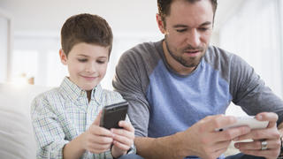 Father and son (8-9) using mobile phone, Vater und Sohn (8-9) Verwenden-Mobiltelefon Keine Weitergabe an Drittverwerter.