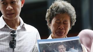Madam Wong and her son Daniel Tan, hold a picture of her son Tan Chong Ling who was aboard missing Malaysia Airlines flight MH370, on the one year anniversary of its disappearance at a remembrance event, in Kuala Lumpur, March 8, 2015. Malaysia's Prime Minister Najib Razak said on Sunday Malaysia remains committed to the search for the missing MH370 jetliner a year after it vanished without trace and he is hopeful it will be found. REUTERS/Olivia Harris (MALAYSIA - Tags: TRANSPORT DISASTER ANNIVERSARY)