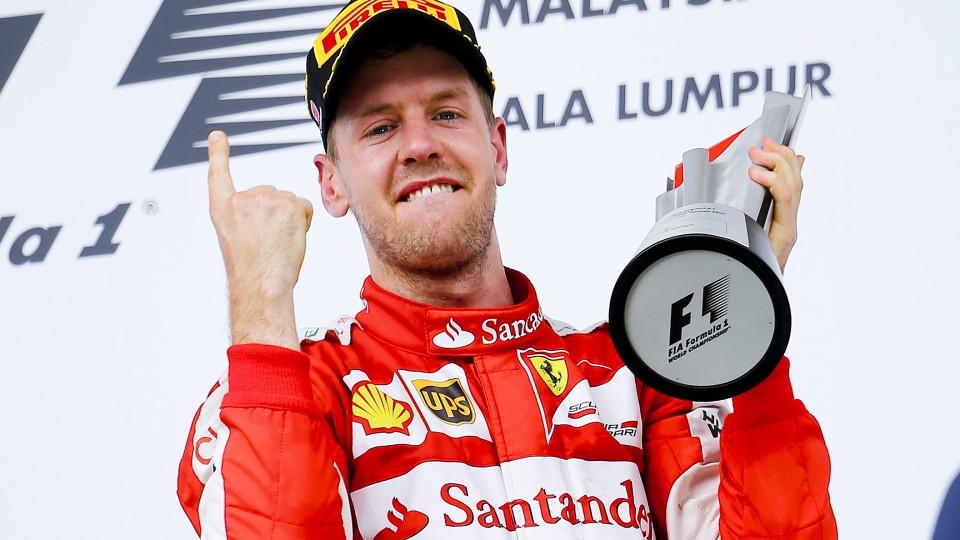 epa04684792 German Formula One driver Sebastian Vettel of Scuderia Ferrari celebrates with his first place trophy after winning the 2015 Formula One Grand Prix of Malaysia in Sepang, Malaysia, 28 March 2015. EPA/DIEGO AZUBEL +++(c) dpa - Bildfunk+++