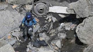 A French rescue worker inspects the debris from the Germanwings Airbus A320 at the site of the crash, near Seyne-les-Alpes, French Alps March 29, 2015. The young German co-pilot, Andreas Lubitz, suspected of deliberately crashing a passenger plane in the French Alps, killing all 150 people on board including himself, told his girlfriend he was in psychiatric treatment, and that he was planning a spectacular gesture that everyone would remember, the German daily Bild reported on Saturday. Picture taken March 29, 2015.    REUTERS/Gonzalo Fuentes