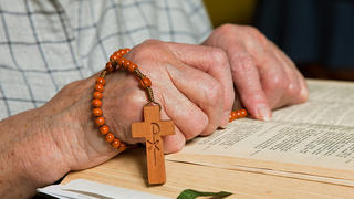 Alte Frau liest in der Bibel und betet