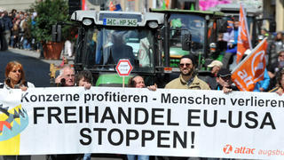 Demonstranten protestieren am 18.04.2015 in Augsburg (Bayern) mit einem Transparent auf dem steht «Freihandel EU-USA stoppen» gegen das geplante Freihandelsabkommen TTIP. Foto: Stefan Puchner/dpa (zu dpa "Tausende protestieren gegen Freihandelsabkommen" am 18.04.2015) +++(c) dpa - Bildfunk+++