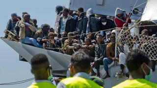 epa04716269 Some of a group of 545 migrants sit on the deck of the Italian navy 'Chimera' vessel while rescue workers gather in front of it as the vessel arrives in Salerno, Italy, 22 April 2015. Of these migrants, about fifty will remain in Campania region, the others will be transferred in Piemonte, Lombardia, Liguria, Veneto, Emilia Romagna, Lazio and Calabria regions. More than 600 would-be asylum seekers reached Italy's shores early 22 April, days after a deadly Mediterranean shipwreck, while top officials from the European Union and African Union were due to discuss migration at talks in Brussels. The Italian navy wrote on Twitter that 446 migrants who were rescued Tuesday some 150 kilometers south-east of the coast of the southern region of Calabria were disembarked in Augusta, Sicily. A further 112 migrants, picked up by the coast guard late on Tuesday from a sinking dinghy at about 90 kilometers north-east of Tripoli, reached the island of Lampedusa, Italy's southern outpost. EPA/CIRO FUSCO +++(c) dpa - Bildfunk+++