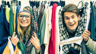 Young hipster couple in love at the weekly cloth market - Best friends sharing free time having fun and shopping in the old town - Lovers enjoying everyday life moments on a vintage filtered look