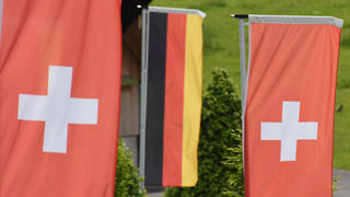 Die deutsche und die Schweizer Flaggen hängen am 25.05.2015 in Feusiberg in der Schweiz. Foto: Patrick Seeger/dpa (zu: "Schweiz nennt Namen möglicher deutscher Steuerbetrüger" vom 25.05.2015) +++(c) dpa - Bildfunk+++