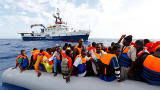 ARCHIV - HANDOUT - Eine Aufnahme vom 04.10.2014 zeigt 105 Flüchtlinge, die in einem Schlauchboot vor der italienische Insel Lampedusa darauf warten, ab Bord der «Phoenix» des einzige Schiffes der Flüchtlings-Rettungsstation auf See, gebracht zu werden. Foto: Darrin Zammit Lupi/MOAS.EU/dpa (ACHTUNG: Nur zur redaktionellen Verwendung und nur bei Nennung der Quelle "Darrin Zammit Lupi/MOAS.EU/dpa") (zu dpa "Der Osten der EU sagt Nein zu Flüchtlingsquoten" am 26.05.2015) (MALTA OUT; MLTOUT; NO ACCESS MALTA) +++(c) dpa - Bildfunk+++