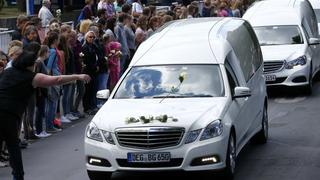 People throw flowers on hearses carrying coffins with remains of victims of the Germanwings flight 4U 9525 plane disaster as they drive past the Joseph-Koenig-Gymnasium high school in Haltern am See, Germany June 10, 2015, where 16 of the victims went to school. Forty four coffins with the victims' remains from the Germanwings crash on March 24 were flown from France to Germany.   REUTERS/Ralph Orlowski 