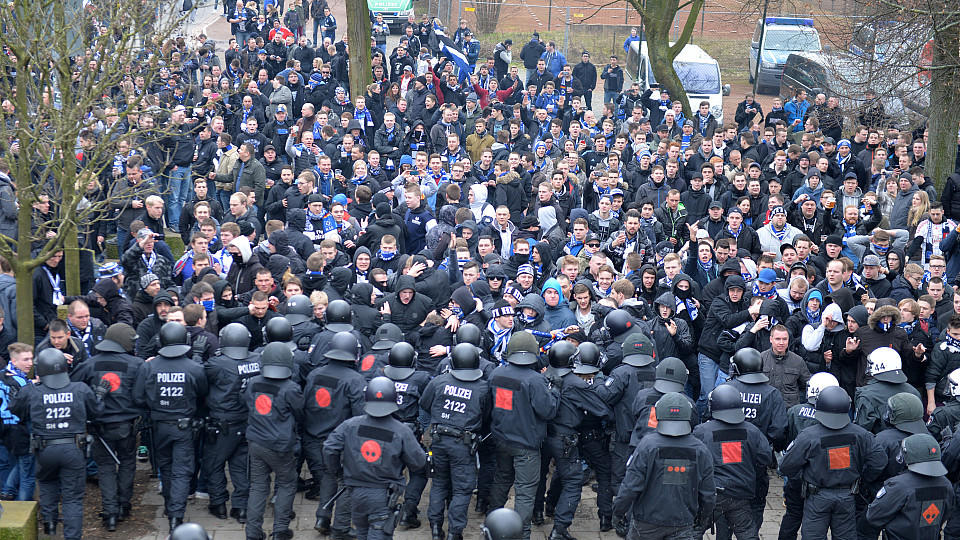 Polizisten versuchen eine Gruppe Fans des Hamburger SV aufzuhalten.