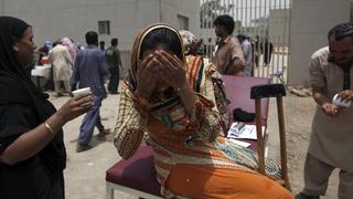 A woman wets her face to cool off, while sitting outside Jinnah Postgraduate Medical Centre (JPMC) during intense hot weather in Karachi, Pakistan, June 23, 2015. A devastating heat wave has killed more than 400 people in Pakistan's southern city of Karachi over the past three days, health officials said on Tuesday, as paramilitaries set up emergency medical camps in the streets. REUTERS/Akhtar Soomro 