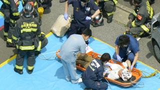 A passenger receives medical treatment from rescue workers after their Shinkansen bullet train made an emergency stop in Odawara, south of Tokyo, in this aerial view photo taken by Kyodo June 30, 2015. A Japanese Shinkansen bullet train made an emergency stop on Tuesday and a passenger was found at the entrance of a carriage covered in flammable liquid, officials said. Media reports said a man in his 30s had set himself on fire. Two people were reported to be in cardiac arrest after smoke was detected on the train, which was bound for the western city of Osaka from Tokyo.      Mandatory credit REUTERS/Kyodo ATTENTION EDITORS - FOR EDITORIAL USE ONLY. NOT FOR SALE FOR MARKETING OR ADVERTISING CAMPAIGNS. MANDATORY CREDIT. JAPAN OUT. NO COMMERCIAL OR EDITORIAL SALES IN JAPAN.  THIS IMAGE WAS PROCESSED BY REUTERS TO ENHANCE QUALITY, AN UNPROCESSED VERSION WILL BE PROVIDED SEPARATELY.