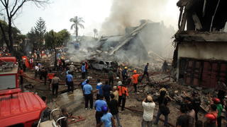 epa04824568 Indonesian rescuers extinguish a fire after a military plane crashed while they search for victims in Medan, North Sumatra, Indonesia, 30 June 2015. At least people 20 were killed when a military transport plane crashed into a residential area of Indonesia's Medan city and burst into flames, a hospital staffer said. The Hercules C-130 plane was carrying 12 crew members and an unknown number of passengers, according to local military commander Dwi Putranto. EPA/DEDI SAHPUTRA +++(c) dpa - Bildfunk+++