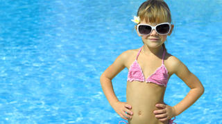  girl near the swimming in hat and sun glasses