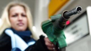 Eine junge Autofahrerin hält eine Zapfpistole einer Tanksäule nach der Betankung ihres Fahrzeuges in einer Hand, aufgenommen am 05.03.2003 an einer Tankstelle in Magdeburg. Eine neue Preisrunde für Benzin wurde eingeläutet. Jetzt müssen Autofahrer an den Zapfsäulen wieder genauso viel bezahlen wie im Rekordmonat Februar. Unter der Führung von Esso erhöhten die Mineralölkonzerne ihre Preise um drei Cent je Liter Benzin und Diesel. Damit kostet Normalbenzin wieder 1,14 Euro je Liter, Super 1,16 Euro und Dieselkraftstoff 97 Cent.