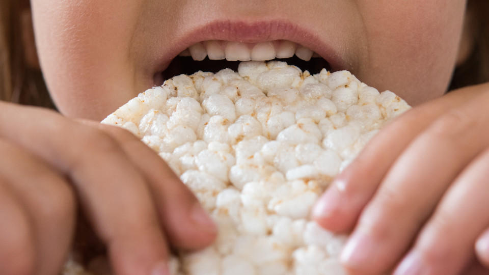 Ein Kind isst eine Reiswaffel