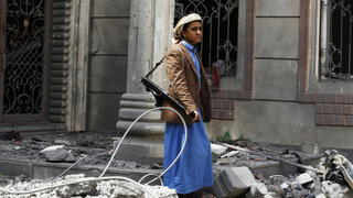 epa04833935 A young armed Yemeni walks over the rubble of the house of a Yemeni army commander loyal to the Houthis after it was hit by two airstrikes allegedly carried out by the Saudi-led coalition in Sana?a, Yemen, 06 July 2015. The UN continues to call for the implemention of a cease-fire between the warring factions in Yemen until the end of the fasting month of Ramadan in order to allow for humanitarian aid to be delivered to the millions of Yemenis in need of assistance. EPA/YAHYA ARHAB +++(c) dpa - Bildfunk+++