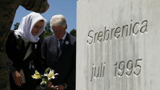 Former United States president Bill Clinton places flowers during a ceremony marking the 20th anniversary of the Srebrenica massacre in Potocari, near Srebenica, Bosnia and Herzegovina July 11, 2015. Abandoned by their U.N. protectors toward the end of a 1992-95 war, 8,000 Muslim men and boys were executed by Bosnian Serb forces over five July days, their bodies dumped in pits then dug up months later and scattered in smaller graves in a systematic effort to conceal the crime. The woman at left is unidentified.   REUTERS/Antonio Bronic 