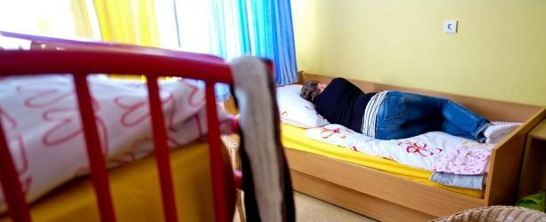 Eine junge Frau posiert auf einem Bett in einem Zimmer im Frauenhaus in Nienburg (Niedersachsen). Foto: Peter Steffen/dpa (zu dpa-Umfrage vom 30.08.2013) +++(c) dpa - Bildfunk+++