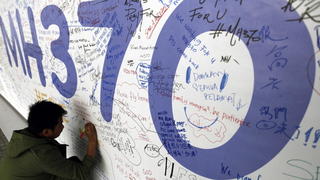 epa04865677 (FILE) A file picture dated 13 March 2014 shows a passenger writing messages for the passengers of missing Malaysian Airline flight MH370 on a banner at Kuala Lumpur International Airport, Malaysia. The Australian government minister in charge of the MH370 search operation in the southern Indian Ocean said 30 July 2015 that if the wreckage found on Reunion Island is from the missing flight, it would prove authorities were looking in the right area. A two-metre-long piece of debris covered in small shells was found on 29 July 2015 on the coast near Saint-Andre on the eastern side of La Reunion, local media reports said. Beijing-bound Malaysia Airlines flight MH370 disappeared one hour after take-off from Kuala Lumpur on March 8, 2014. The Boeing 777 has never been found and is presumed to have crashed into the sea. EPA/MAK REMISSA +++(c) dpa - Bildfunk+++