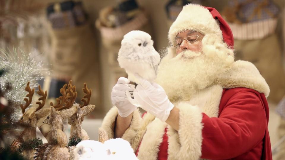 Weihnachtsmann posiert mit Schneeeule in London im Kaufhaus Selfridges