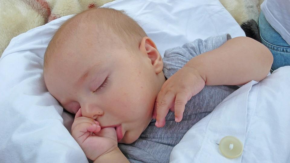 Baby schlaeft und lutscht am Daumen | sleeping baby sucking thumb