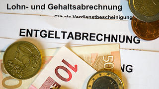 ARCHIV - ILLUSTRATION - Auf Lohn- und Gehaltsabrechnungen (Entgeltabrechnungen) liegen Euromünzen und Eurogeldscheine, aufgenommen am 31.01.2013 in Dresden (Sachsen). Foto: Arno Burgi/dpa (zu dpa "Mini-Inflation sorgt für Rekordanstieg der Reallöhne in Deutschland" vom 22.09.2015) +++(c) dpa - Bildfunk+++