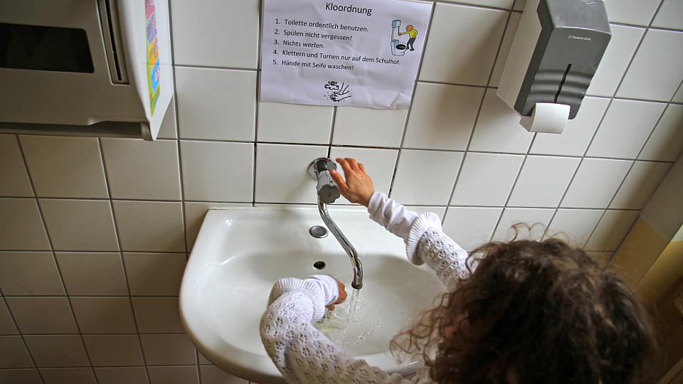 Eine Schülerin wäscht sich die Hände in einem WC in der Grundschule am «Weißen See» am 23.04.2013 in Berlin. In vielen Schulen fehlt das Geld für eine Sanierung der Schulklos. Foto: Stefan Schaubitzer/dpa (zu dpa KORR: «Problemfall Schultoilette - Fü