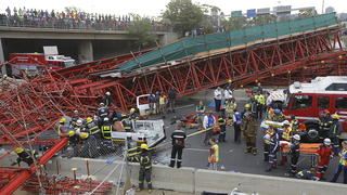 epa04977447 Paramedics try to save a patient in a taxi that was crushed by a pedestrian bridge that collapsed over the countries busiest motorway in Johannesburg, South Africa, 14 October 2015. The bridge collapsed on the highway blocking both sides and trapping at least two cars. The driver of the taxi died in the vehicle. EPA/KIM LUDBROOK +++(c) dpa - Bildfunk+++