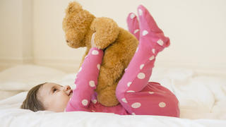 Girl (2-3) lying on bed with teddy bear, liegt mit Teddy im Bett Keine Weitergabe an Drittverwerter.